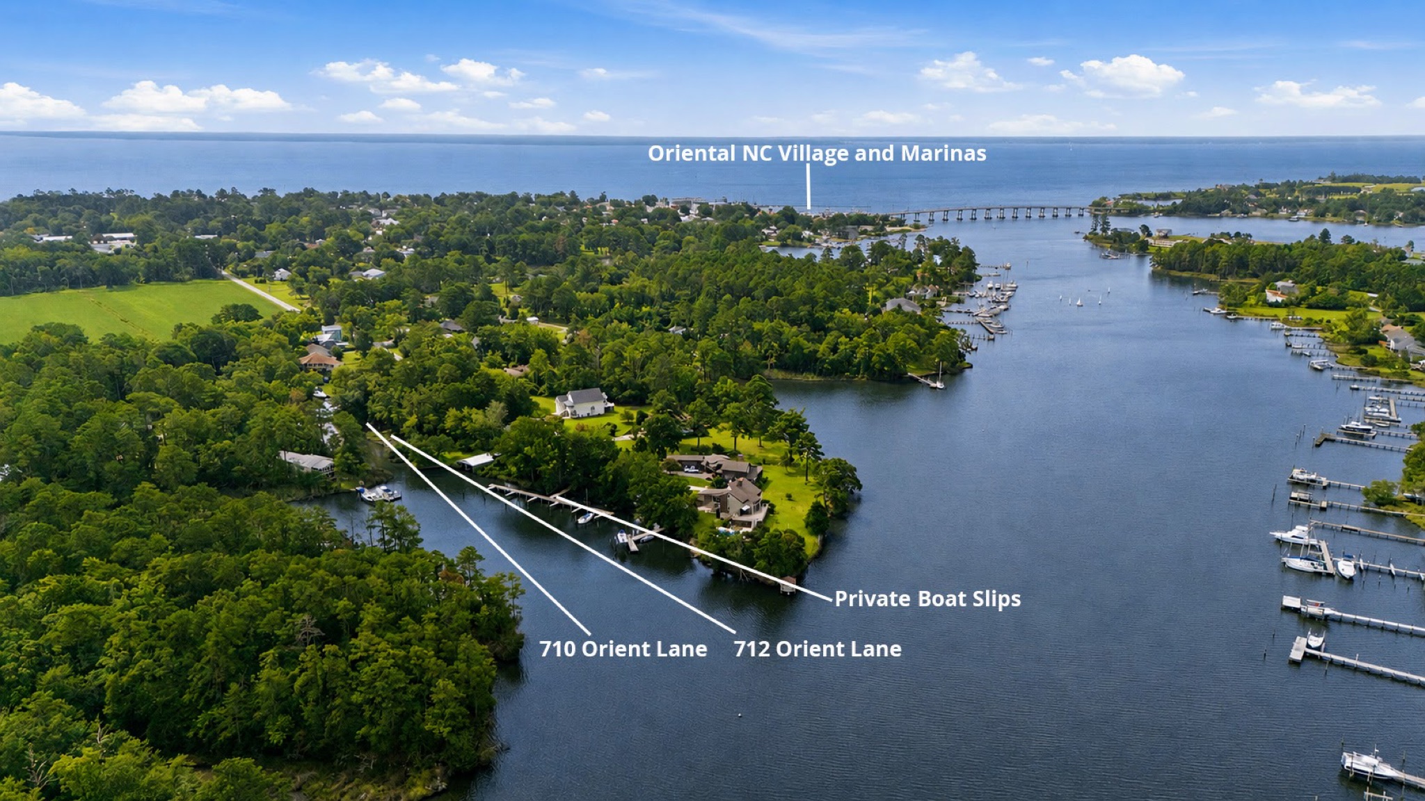 Aerial view showing 712 Orient Lane, the marina slips, and Oriental village